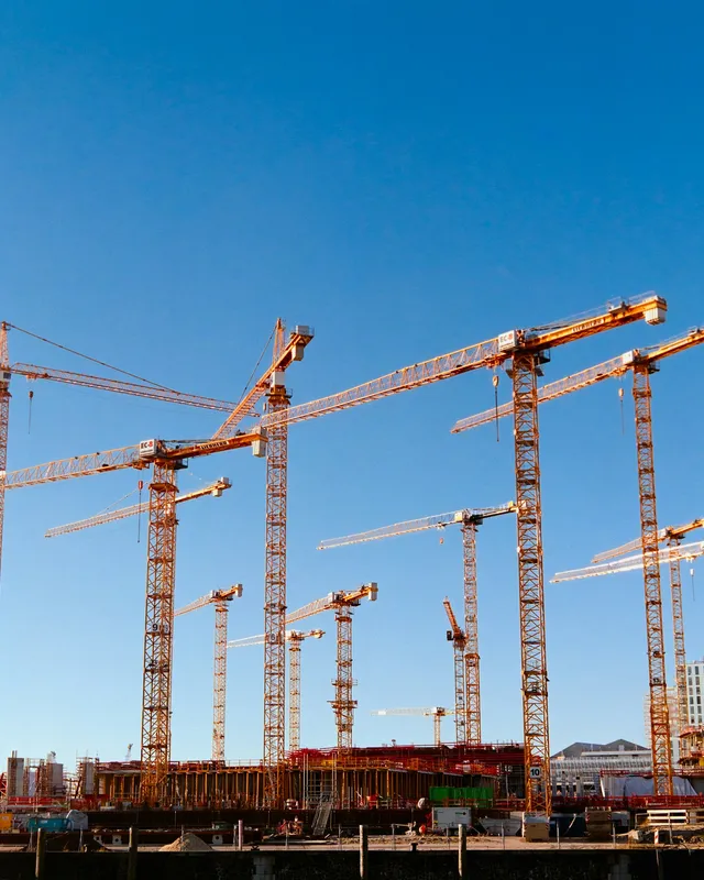 a bunch of cranes that are standing in the air