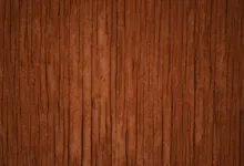 A close-up of dark brown wood grain with vertical cracks
