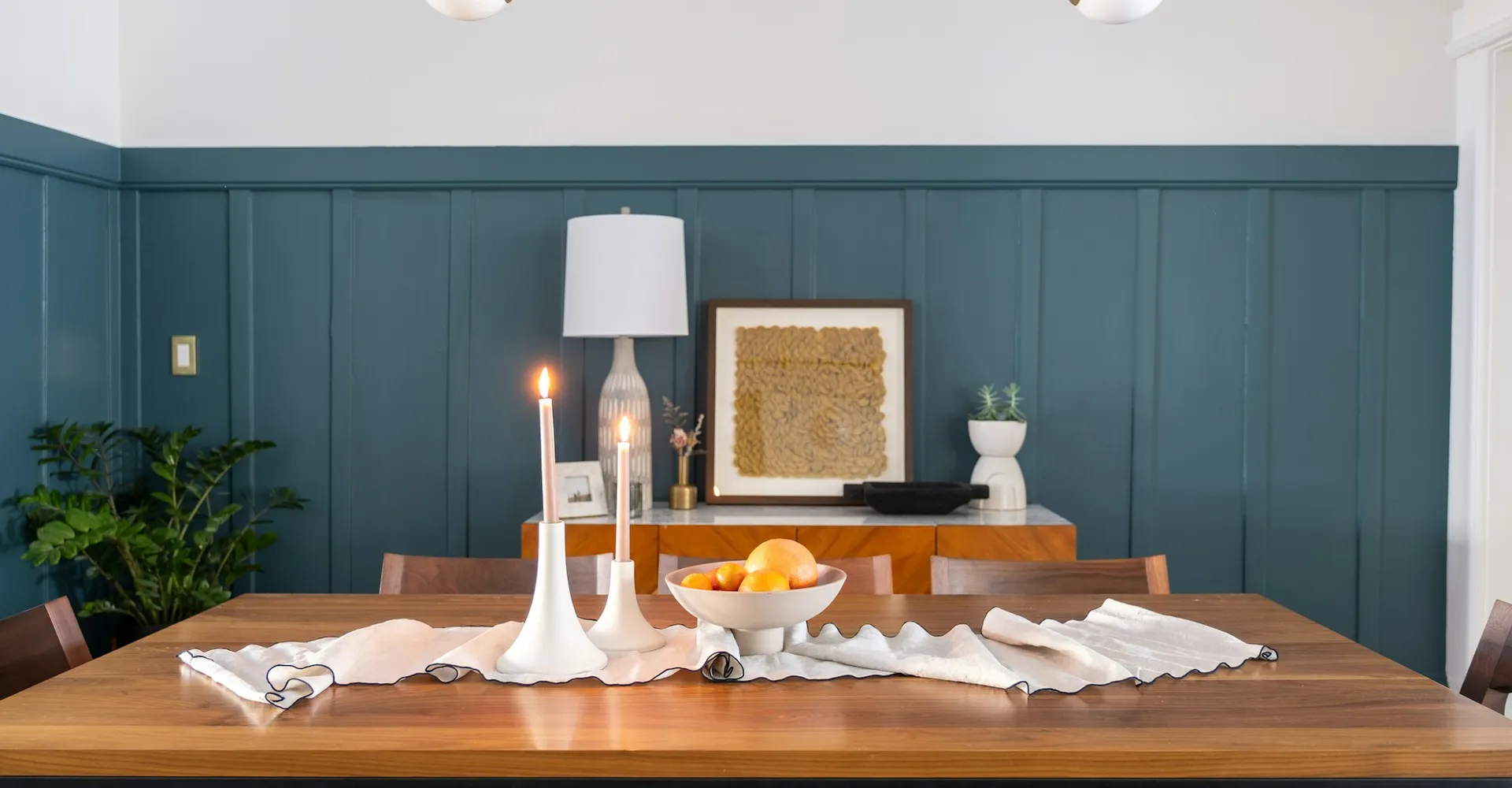 a dining room table with a bowl of fruit on it