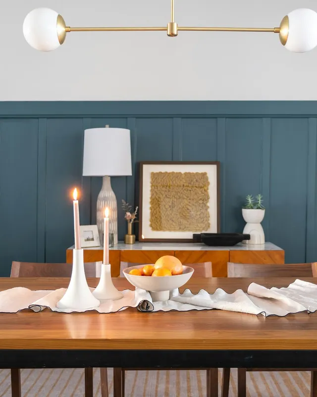a dining room table with a bowl of fruit on it