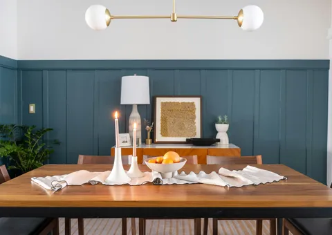 a dining room table with a bowl of fruit on it