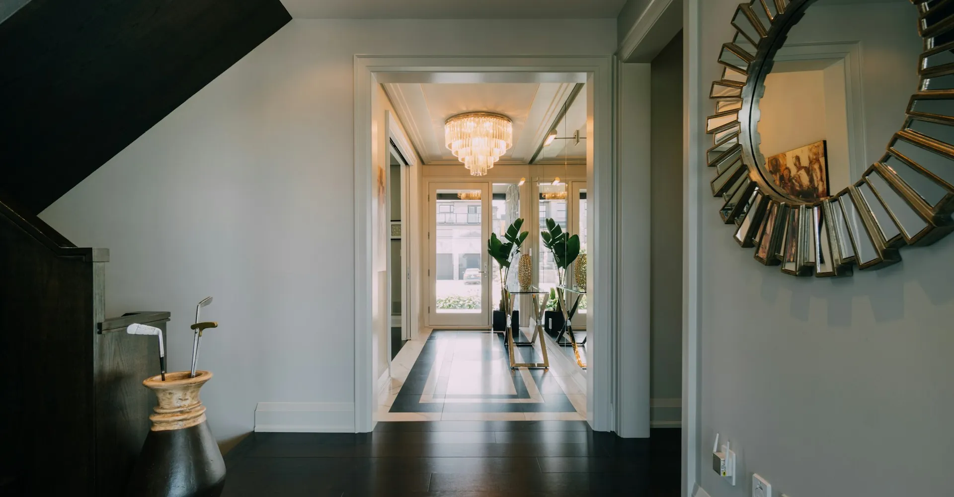a hallway with a large mirror and a chandelier