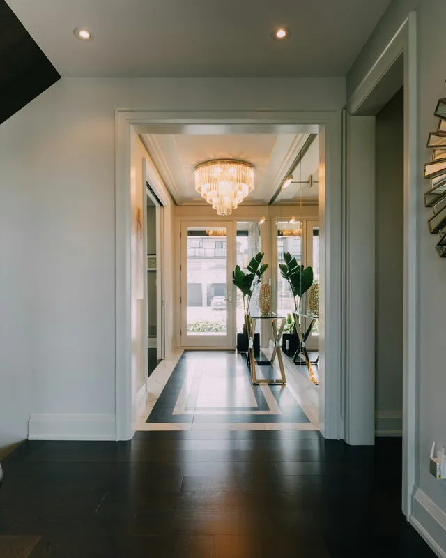 a hallway with a large mirror and a chandelier