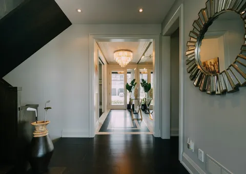 a hallway with a large mirror and a chandelier