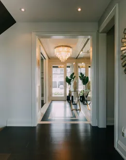 a hallway with a large mirror and a chandelier
