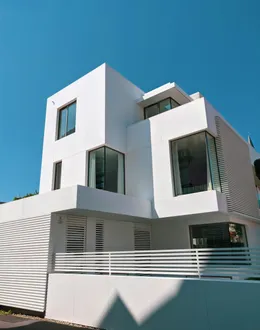 A two story house with a lot of windows and balconies — detail 1