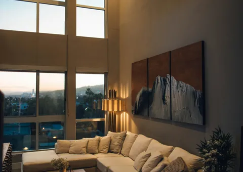 gray padded chaise couch beside window